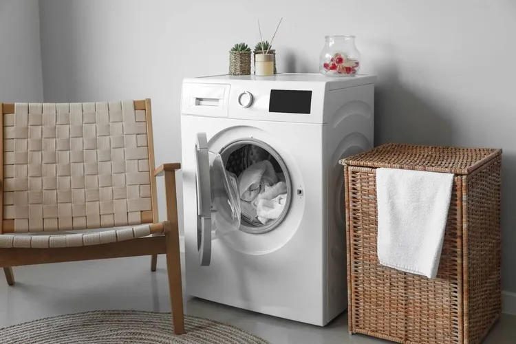 Een wasapparaat naast een wasmand en stoel