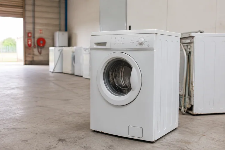 Oude wasmachine op een afgeschermde inzamelplek