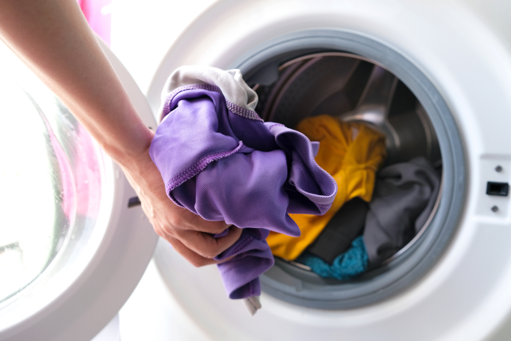 Washing machine and dryer set lifetime hand putting clothes in the drum