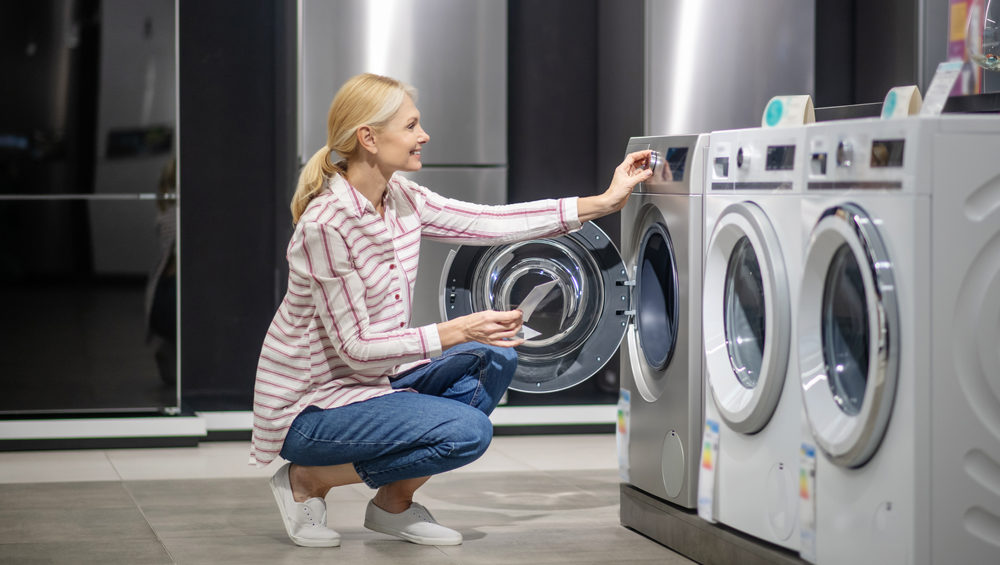 Washing machine lifespan woman choosing new washing machine e1690975962645