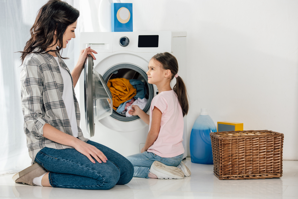 Washing machine lifespan woman with daughter loading washing machine