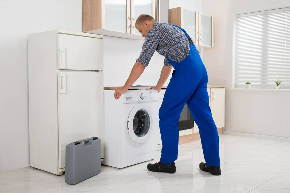 Washing machine vibration dampers worker install a washing machine