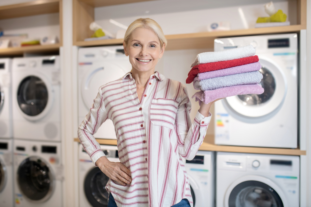 Washing machine with steam function woman with clean towels